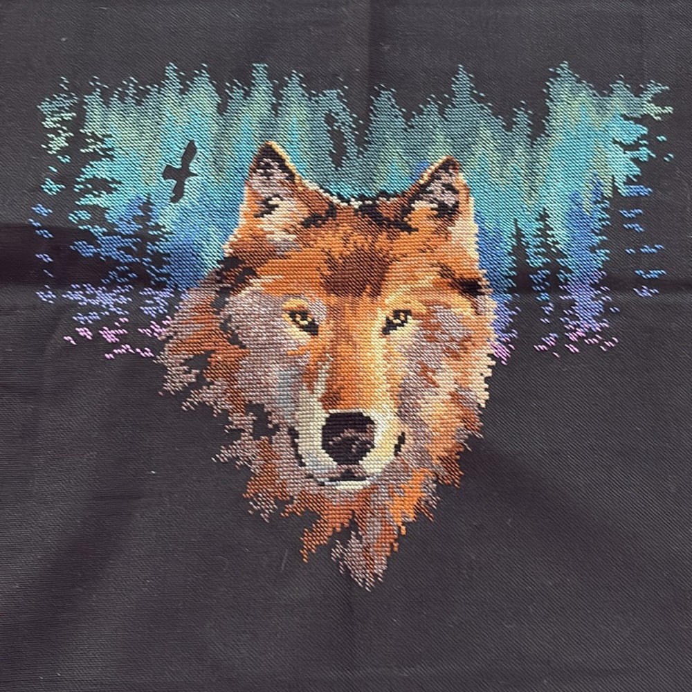 Handmade needlepoint picture of a wolf in the forest